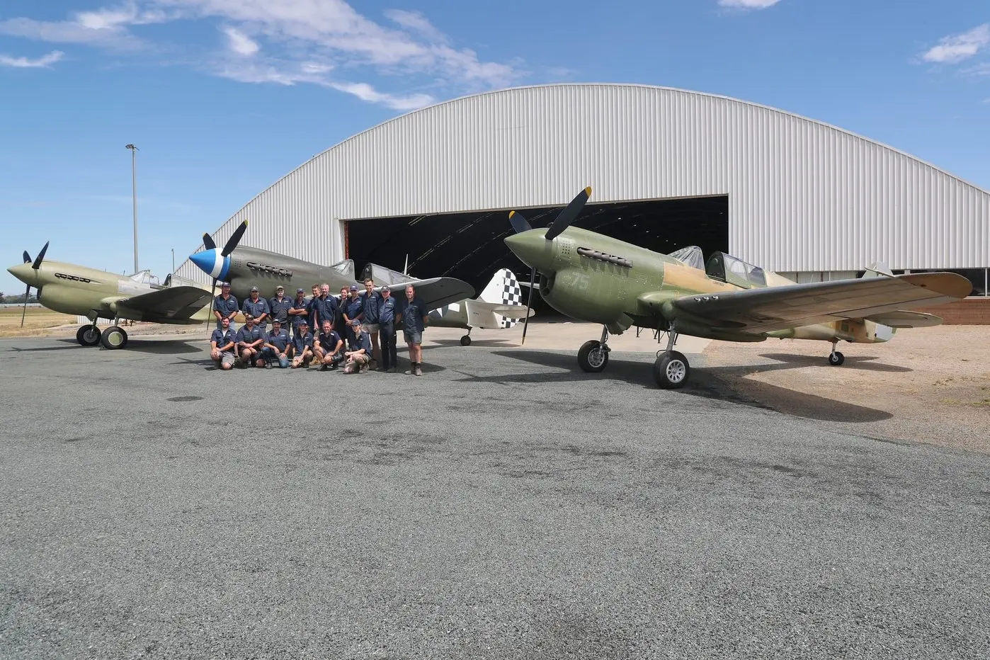 FLYING HISTORY: Members of the Precision Airmotive team based at Wangaratta Airport with three P40s (Kittyhawks) all built there.