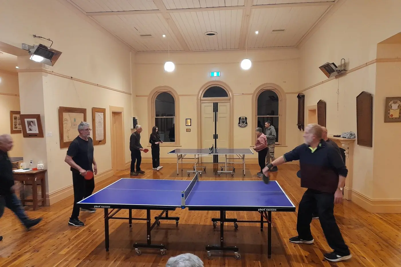 ROCKET RETURNS: At the forefront table, Manni Poulos, Neil Spurzon, Richard Morgan and Adrian Branken exchange a quickfire rally, while at the back table, Neil Brock, Millie and Adam Boskey and June Uebergang discuss a point. PHOTO: Phoebe Morgan.
