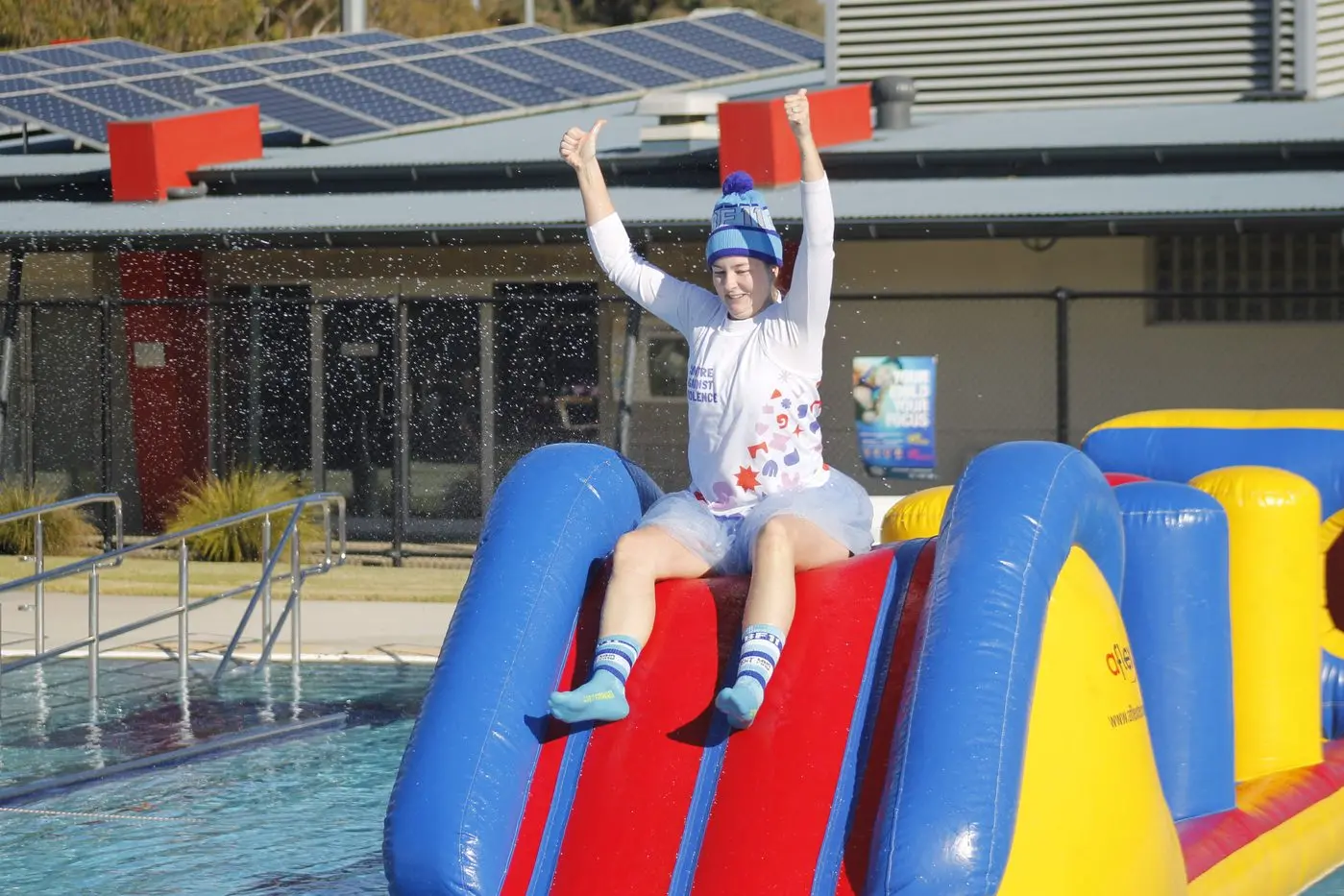 SUPER SLIDE: Brea Setu braces to take the slide after completing the obstacle course at the outdoor pool of WSAC\\'s Big Freeze event. PHOTOS: Bailey Zimmermann
