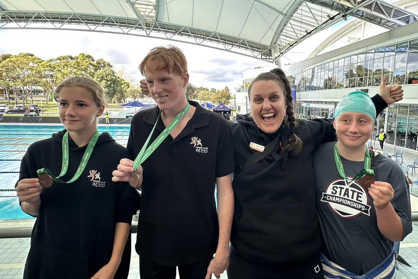 EXCELLENT RESULTS: Lara Pearson (left), Harry White, teacher Rowan Barrow, and Toria Waddell\\u2013Laing at the School Sport Victoria Swimming Championships at Melbourne Sports and Aquatic Centre.
