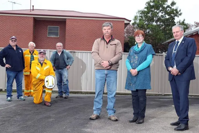 FED UP: CFA members Peter Brick (from left), Jim Buchan, Lachie Gales and Michael Glenister (kneeling), with Moyhu deputy group officer David Bienvenu, VFBV spokesperson Mary-Anne Egan and South Wangaratta first lieutenant Garry Nash. PHOTO: Kieren Tilly 