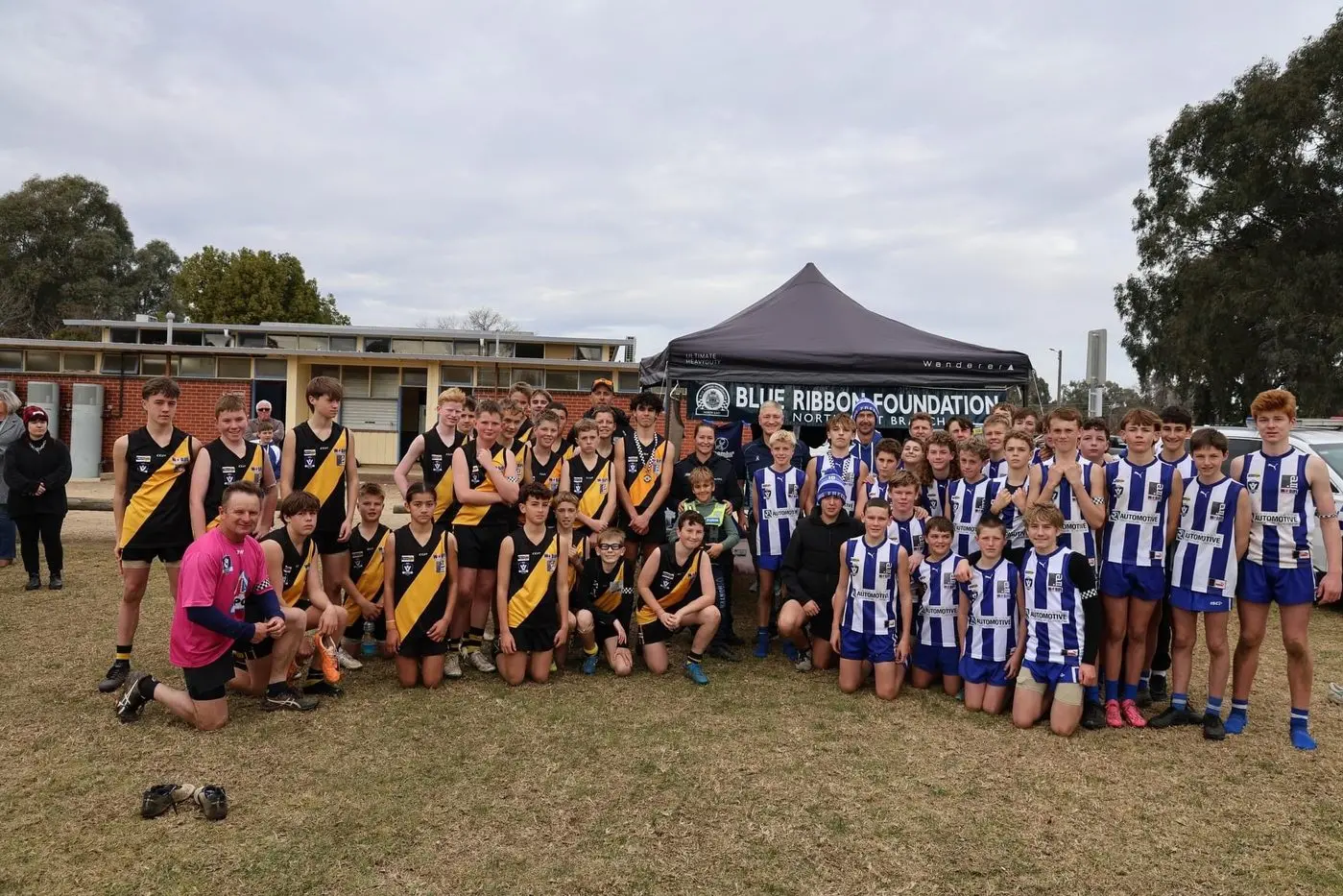 MORE THAN A GAME: Kangaroos and Tigers players, coaching staff, and Victoria Police officers celebrate the true meaning of sport on the the Blue Ribbon Spirit of Sport day.