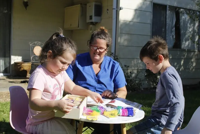 THE FORGOTTEN: Health care worker Melanie Hellebrand with her children Stephanie, 5, and Matthew, 7 on their Everton property. The family has lost access to in-home care after the service was abolished in the wake of a Federal Government announcement of free child care due to the COVID-19 pandemic. PHOTO: Willson Mack\\n