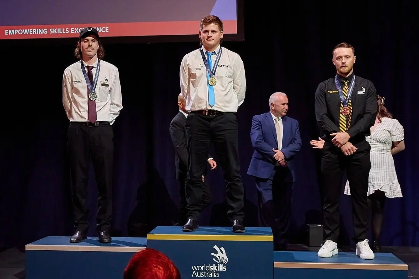 CENTRE STAGE: Michael Twitchett (centre) was announced as the gold medalist in the Heavy Vehicle Skill section at the WorldSkills Australia National Championship. PHOTO: WorldSkills International/WorldSkills Australia