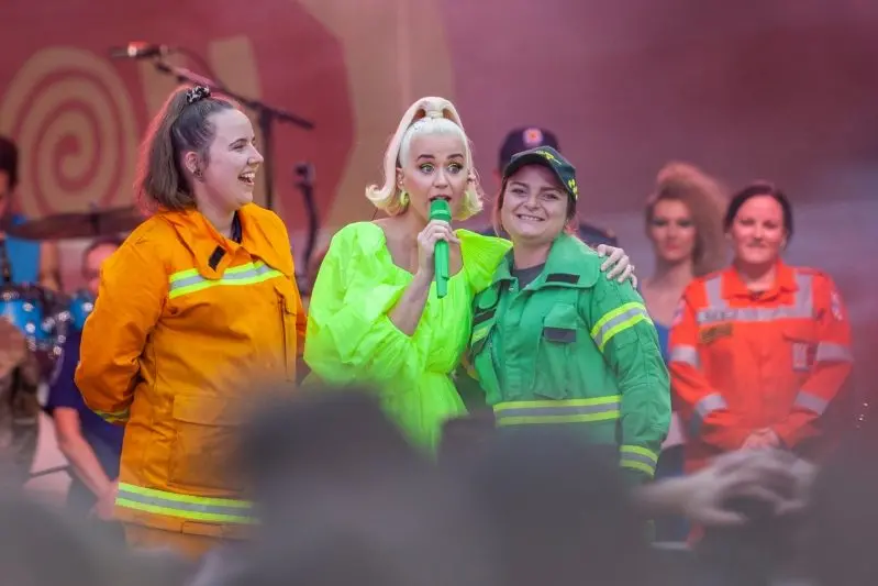 HEROES\\u2019 HERO: Katy Perry poses with emergency service personnel (inset) before the concert, and shared the stage (above) with Whitfield-based DELWP firefighter Stephanie Riley (right) and Corryong CFA volunteer Dara Pilli. For Stephanie, being serenaded by one of her favourite international performers was a dream way to celebrate her 28th birthday. PHOTOS: Jean-Pierre Ronco