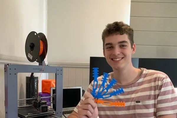 EAGER TO HELP: Galen Catholic College student Ryan Falconer at work at his 3D printer.