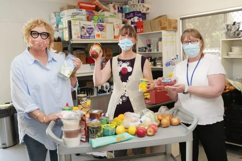 THERE TO HELP: Louisa Hayes, Wangaratta High School counsellor/wellbeing officer, Loretta Waters, Open Door Neighbourhood House executive officer, and Cathy Nesbitt, Anglicare Victoria community development worker with some of the food items available to those in need.  PHOTO: Kieren Tilly