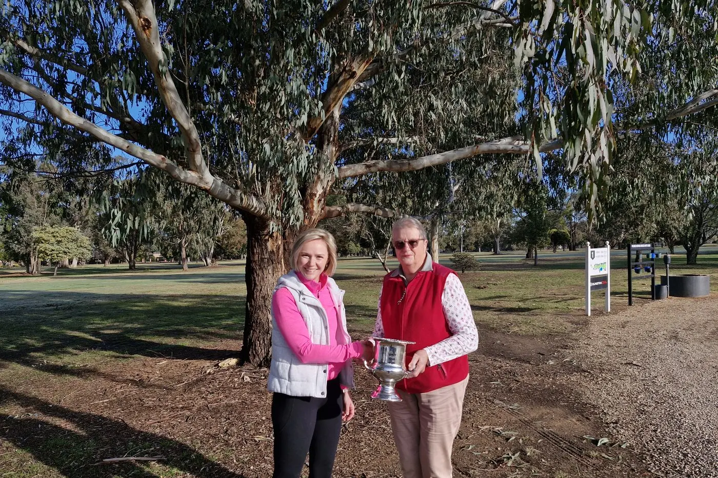 WINNER: Jacqui Hoggan (left) presents Carol Coghill with the winning trophy.