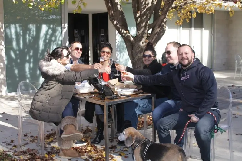 CHEERS ALL ROUND: Melbourne travellers Sahar Farzan (left) with Hayden Thin, Aniyo Rahebi, Shirin Shell, Angus Quarrie, Walter Collins and Nugget the beagle were happy to share a glass of wine at Sam Miranda winery on Monday. \\nPHOTO: Nick Sinis