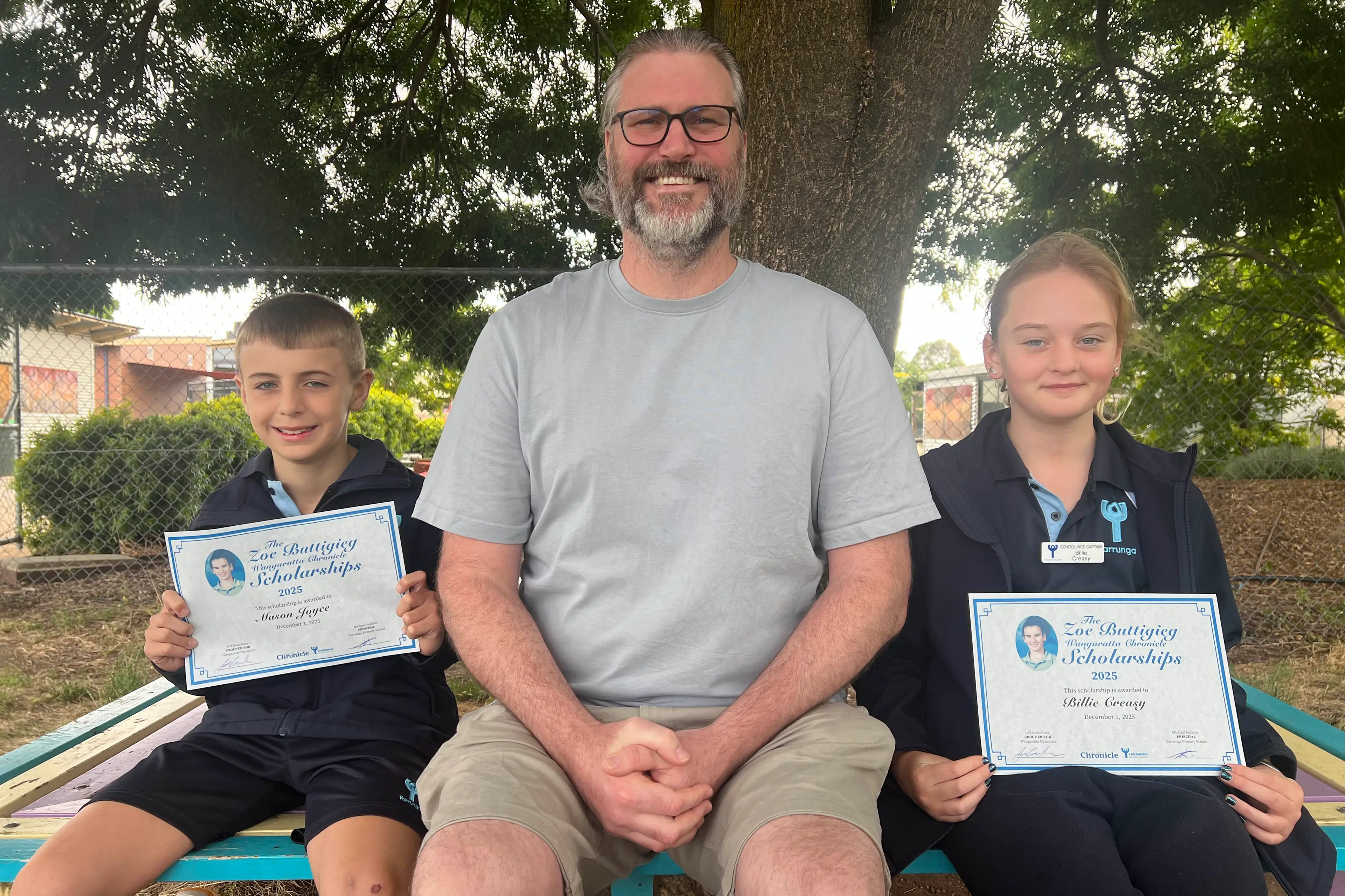 <p>AWARDED: Yarrunga Primary School grade five students Mason Joyce and Billie Creasy were awarded the annual Zoe Buttigieg Wangaratta Chronicle Scholarships on Monday. They are pictured under the Zoe tree with principal Michael Jenkins. PHOTO: Jeff Zeuschner</p>\\n