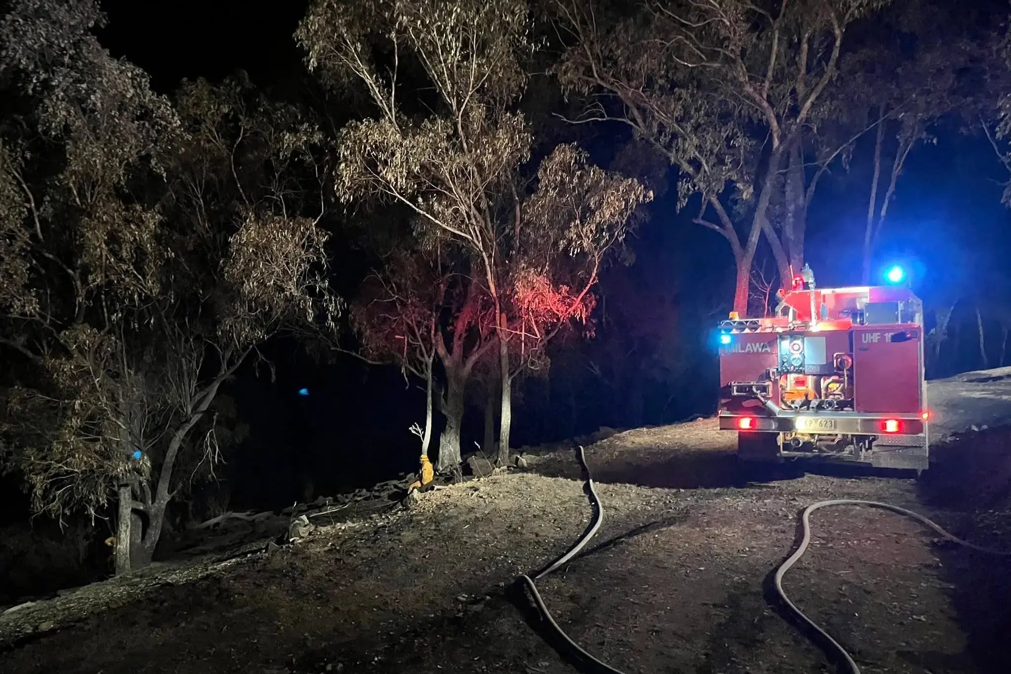 <p>BLACKING OUT: Fire crews attended to some smouldering trees along the containment line of the Markwood fire on Monday night. PHOTO: Milawa CFA</p>\\n