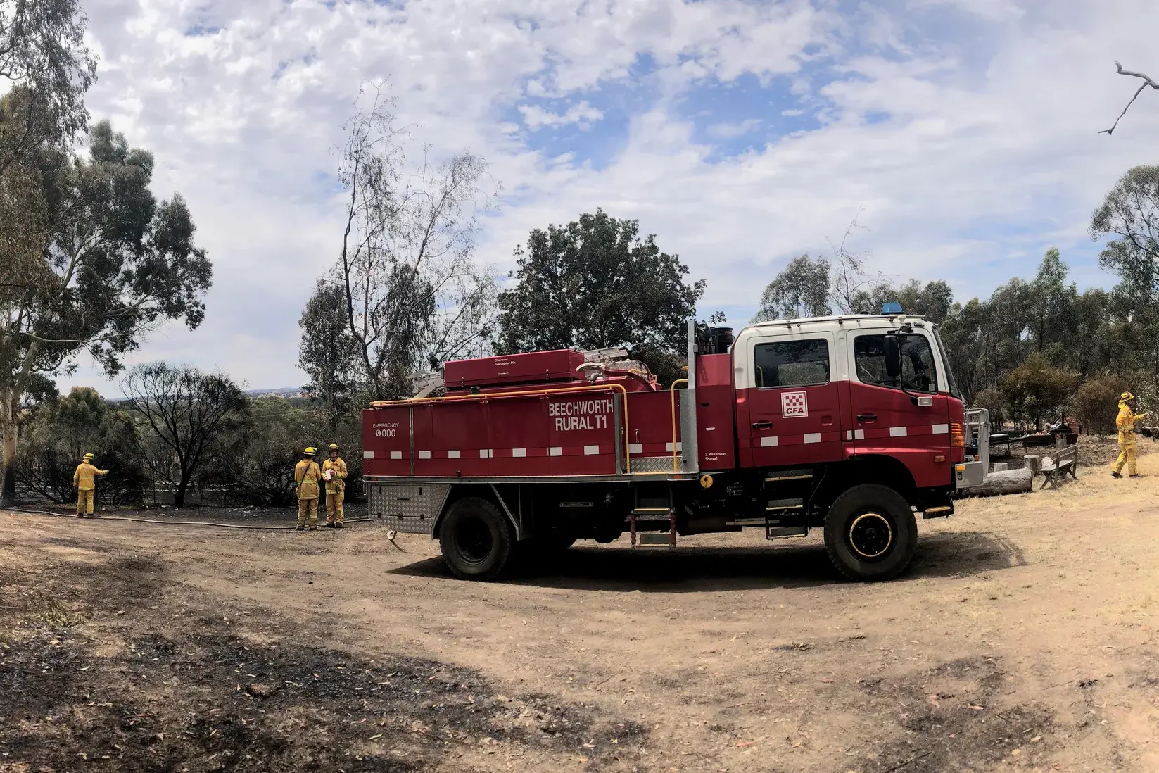 <p>HEROES: Firefighters hose down a blacked out paddock in Markwood during last Thursday\\'s fire. PHOTO: Leonie Brien</p>\\n