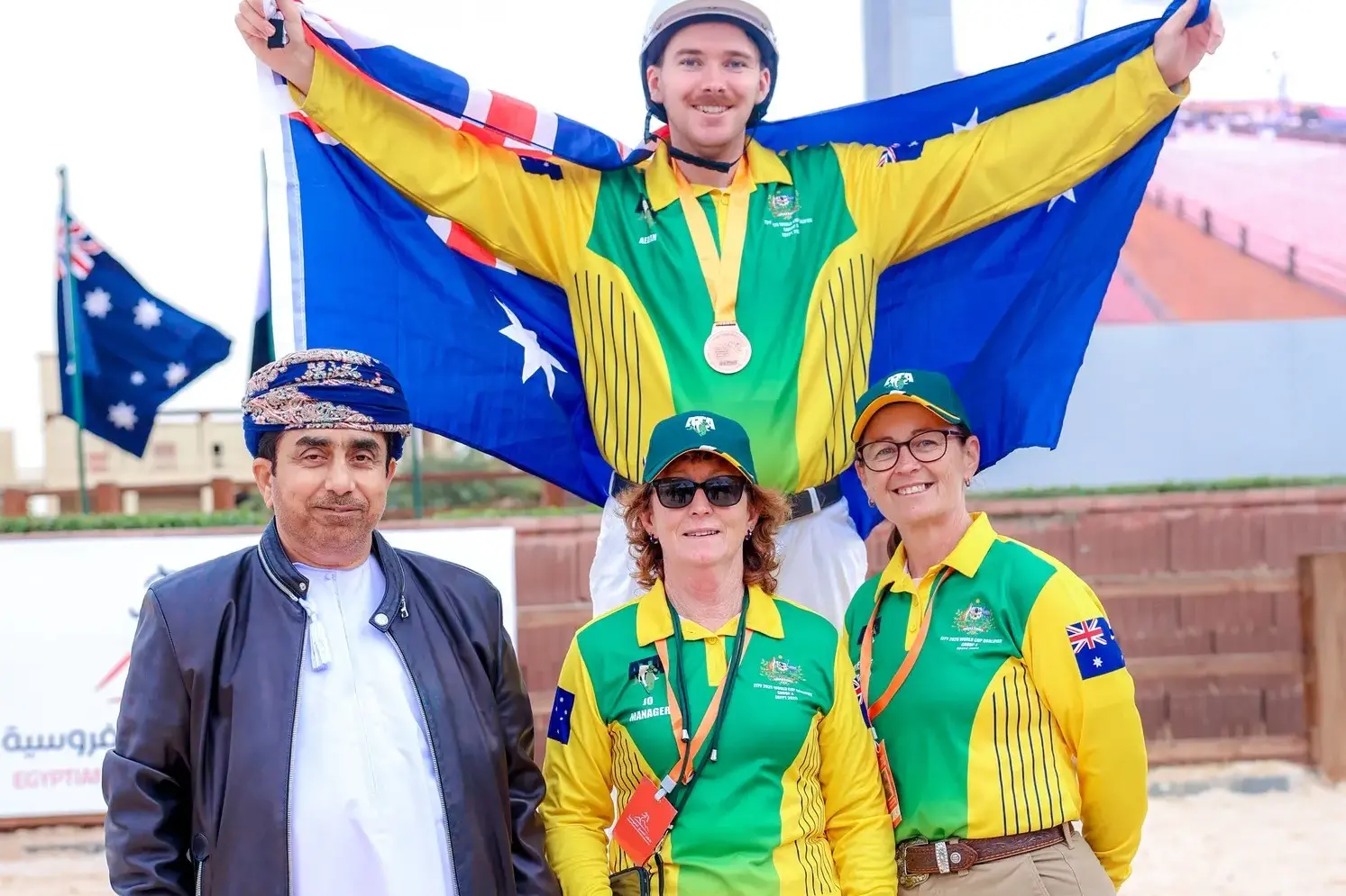 <p>TRUE BLUE: Aedan Staats yields the Australian flag as he celebrates his third individual place overall with (front, from left); International Tent Pegging Federation president Mohamed Issa Alfairus, manager Jo Watson and team coach Renee Craig. PHOTO: Egyptian Equestrian Federation </p>\\n