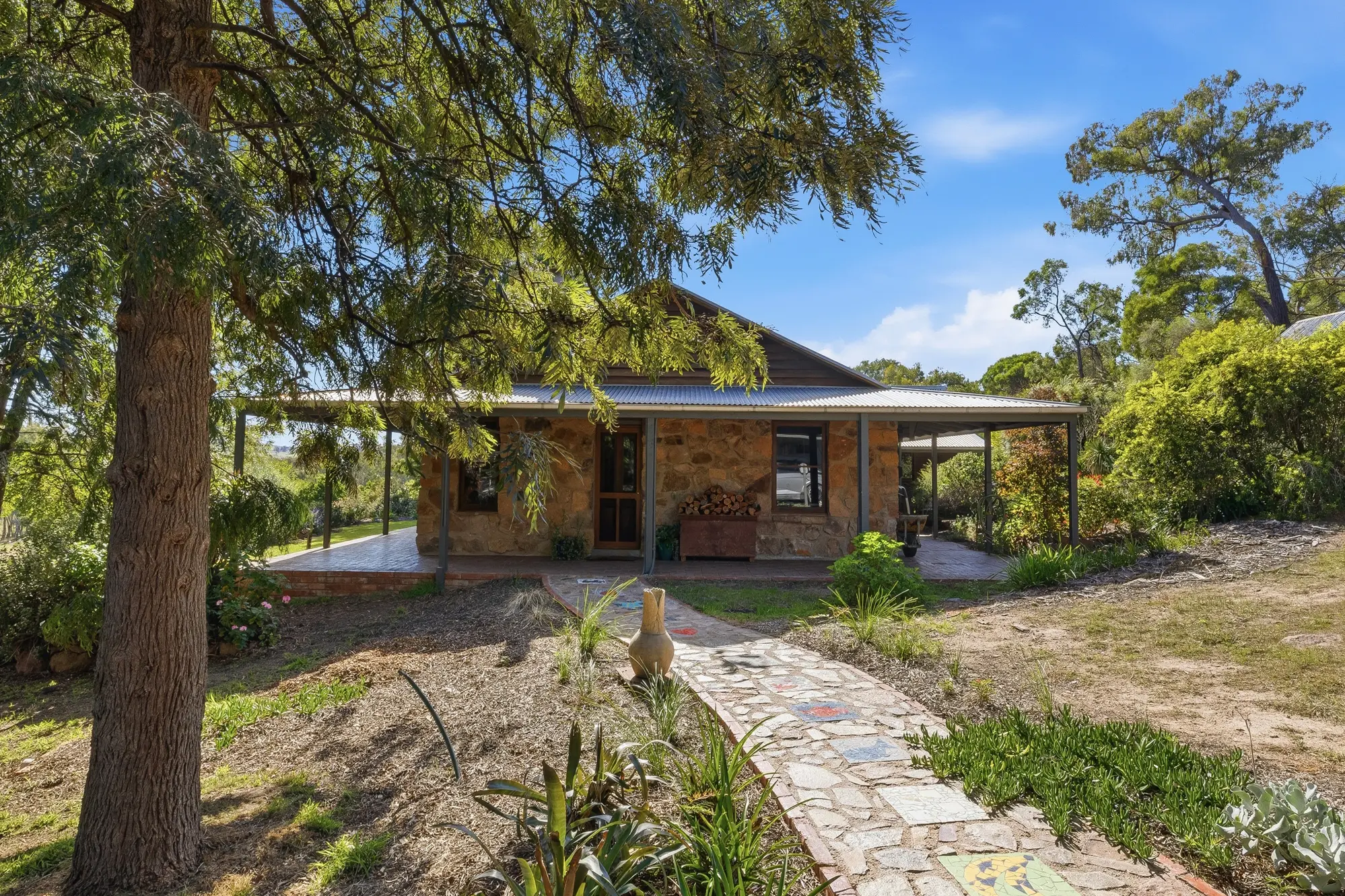<p>The home features three spacious bedrooms with storage, a timber kitchen complete with a feature wood combustion stove, and a separate lounge with slate flooring, expansive windows and beautiful rural outlooks. </p>\\n